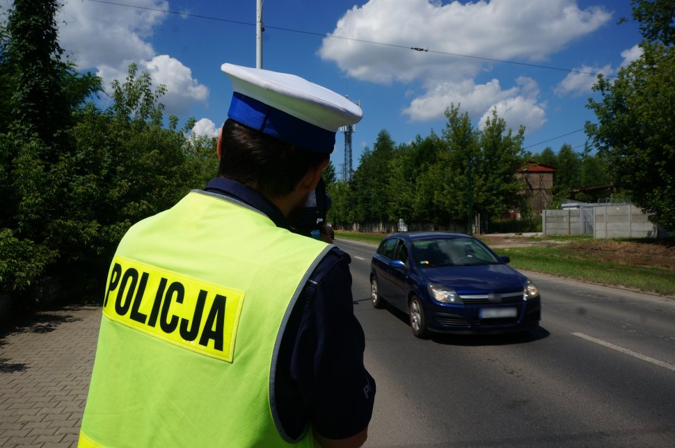 Mundurowy z drogówki w trakcie prowadzenia pomiaru prędkości na jednej ze świętochłowickich ulicy przy pomocy ręcznego miernika. W tle widać przemieszczające się pojazdy