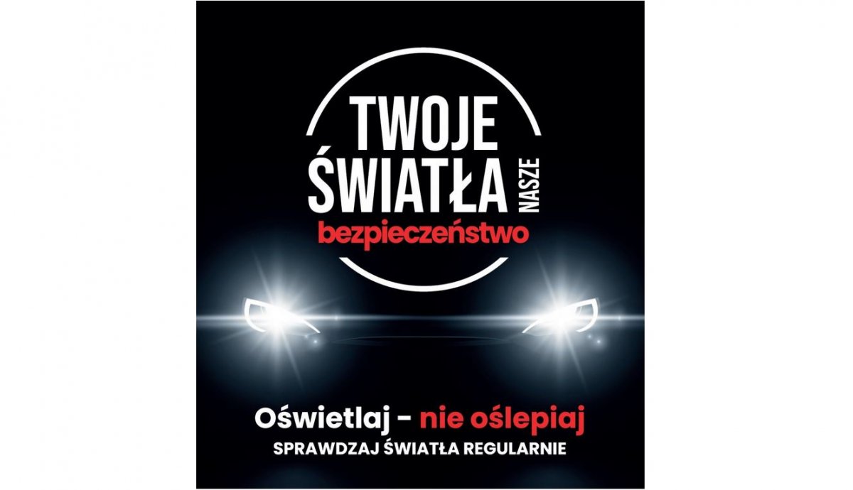 Plakat przedstawiający auto na czarnym tle z włączonymi światłami. Na górze napis „Twoje światła-Nasze bezpieczeństwo”, poniżej napis Oświetlaj, nie oślepiaj, 