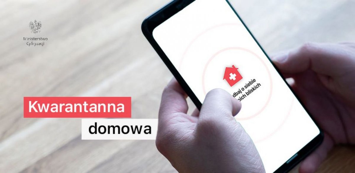 Na zdjęciu zbliżenie na telefon trzymany w dłoniach na którym pokazane jest logo aplikacji. Obok napis Kwarantanna domowa