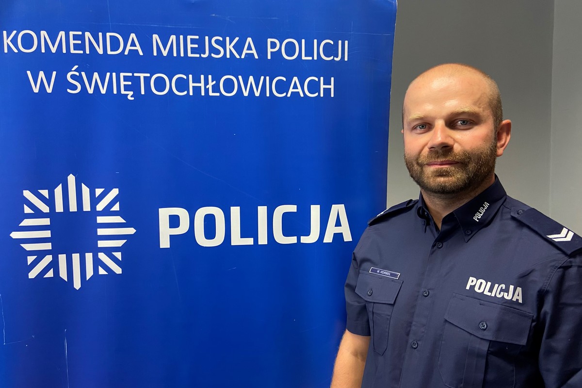 Zdjęcie przedstawia dzielnicowego na tle napisu komenda miejska policji w świętochłowicach