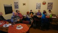 Na zdjęciu grupa seniorów z Polskiego Towarzystwa Niewidomych i Niedowidzących, siedzący przy stole.