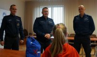 Na zdjęciu dziewczynka, w tle kierownictwo KMP Świętochłowice.