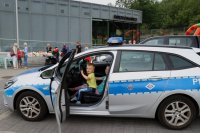 Dziecko siedzące w radiowozie policyjnym podczas festynu rodzinne zorganizowanego na terenie Dwóch Wież KWK Polska