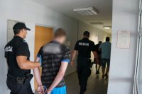 policjanci prowadzący zatrzymanych mężczyzn