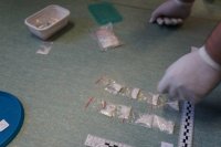 policyjny technik podczas prowadzonych oględzin zabezpieczonych woreczków z amfetaminą