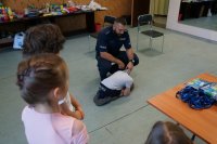 Policjanci świętochłowickiej komendy z najmłodszymi,  podczas prelekcji dotyczącej bezpieczeństwa w trakcie wakacyjnych zajęć w MDK w Świętochłowicach