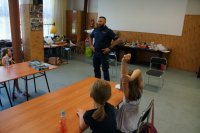 Policjanci świętochłowickiej komendy z najmłodszymi,  podczas prelekcji dotyczącej bezpieczeństwa w trakcie wakacyjnych zajęć w MDK w Świętochłowicach