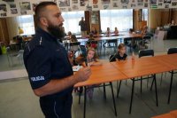 Policjanci świętochłowickiej komendy z najmłodszymi,  podczas prelekcji dotyczącej bezpieczeństwa w trakcie wakacyjnych zajęć w MDK w Świętochłowicach