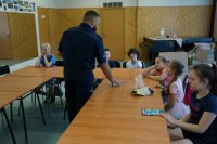 Policjanci świętochłowickiej komendy z najmłodszymi,  podczas prelekcji dotyczącej bezpieczeństwa w trakcie wakacyjnych zajęć w MDK w Świętochłowicach