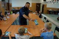 Policjanci świętochłowickiej komendy z najmłodszymi,  podczas prelekcji dotyczącej bezpieczeństwa w trakcie wakacyjnych zajęć w MDK w Świętochłowicach