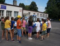 Dzieci biorące udział w półkoloniach w MDK w Świętochłowicach podczas oglądania radiowozu.