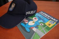 czapka policyjna obok elementarza bezpieczeństwa