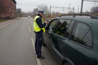 policjant drogówki podczas prowadzenia badania trzeźwości zatrzymanego do kontroli kierującego