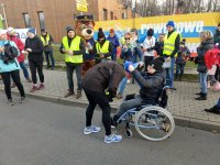 Mateusz podczas zawieszania na szyi medalu uczestnikowi który skończył bieg