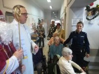 Mundurowa miejscowej komendy podczas wizyty mikołajkowej w świętochłowickim zakładzie Opiekuńczo-Leczniczym wraz z  wolontariuszami i przedstawicielami Fundacji Rodzin Polskich w Świętochłowicach
