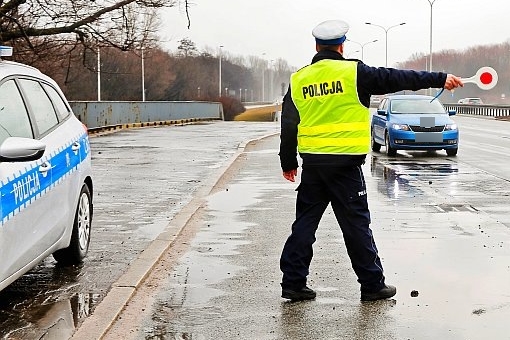 policjant podczas zatrzymywania pojazdu do kontroli drogowej