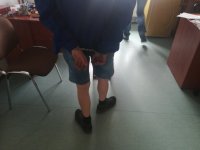 Zatrzymany z założonymi kajdankami. Kajdanki założone  na ręce trzymane z tyłu.