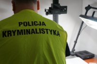 technik kryminalistyki podczas pełnienia słuzby ubrany w kamizelkę z napisem policja kryminalistyka