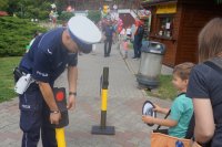 Na zdjęciu policjant ze świętochłowickiego wydziału ruchu drogowego wraz z jednym z uczestników podczas uczenia się zasad bezpieczeństwa na drodze