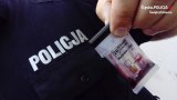 tester narkotykowy trzymany przez mundurowego na tle napisu policja na mundurze