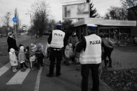 Na zdjęciu jedno ze świętochłowickich skrzyżować. Mundurowi nauczają grupę przedszkolaków bezpiecznego przechodzenia przez jezdnię