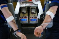 Na zdjęciu przedramiona dwóch policjantów w trakcie oddawania krwi