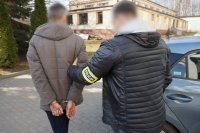 nieumundurowany policjant podczas prowadzenia zatrzymanego mężczyznę