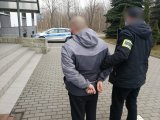 nieumundurowany policjant w trakcie doprawadzenia do miejscowej komendy zatrzymanego mężczyznę zakutego w kajdanki