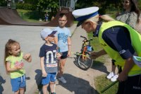 Na zdjęciu funkcjonariusze Wydziału Ruchu Drogowego wraz z podopiecznymi Fundacji Rodzin Polskiech na SkateParku. Funkcjonariuszka wręcza odblaski