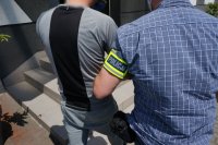 Na zdjęciu nieumundurowany policjant w trakcie prowadzenia zatrzymanego mężczyznę zakutego w kajdanki do budynku świętochłowickiej komendy