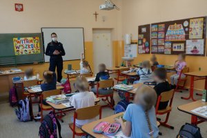 Na zdjęciu policjantka przekazuje dzieciom cenne porady dotyczące ich bezpieczeństwa w drodze do szkoły