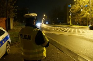 Policjant z rychu drogowego w trakcie prowadenia obserwacji na jednej ze świętochłowickich ulic w godzinach wieczornych pod kątem właściwego oświetlenia pojazdów