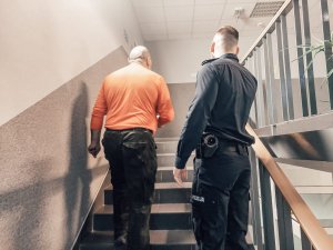 Na zdjeciu policjant odprowadzający do sali wykład rezerwistę