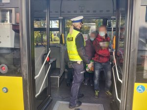 Na zdjęciu policjantka z drogówki w trakcie kontroli autobusu w celu sprawdzenia czy pasażerowie przestrzegają obostrzeń