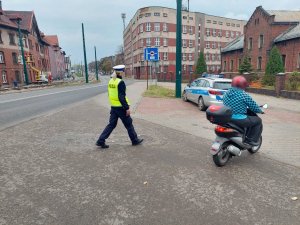 Na zdjeciu policjanci z dorgówki w trakcie zatrzymania do kontroli drogowej kierującego motorowerem.