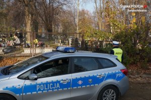 Na zdjęciu policjant z drogówki w trakcie prowadzenia obserwacji cmentarza pod kątem kradzieży