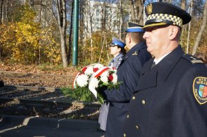 Zbliżenie na Pierwszego Zastepcę Komendanta Miejsckiego Policji w Świętochłowicach oraz Komendanta Strazy Miejskiej i Komendanta Państwowej Straży Pożarnej który niesie wieniec