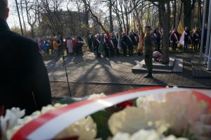 Na zdjęciu zbliżenie na wieniec, w tle widać uczestników miejskich obchodów Święta Niepodległości odbywających się pod pomnikiem Powstańców Śląskich