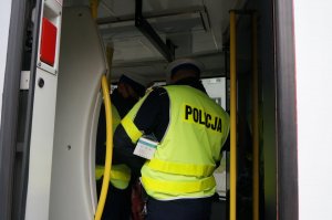 Na zdjęciu widać policjantów wewnątrz tramwaju w trakcie prowadzenia kontroli stosowania się do obostrzeń przed podróżnych