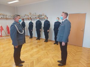 Zastępca Naczelnika Wydziału Prewencji w trakcie składania meldunku Komendantowi Miejskiemu Policji w Świętochłowicach podczas uroczystości slubowania. W tle widac 5 nowo przyjętych policjantów