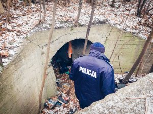 Dzielnicowy w trakcie kontroli bunkru w którym chronią się przed zimnem osoby bezdomne