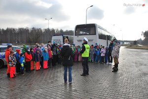 Na zdjęciu policjant oraz grupa dzieci przed autobusem po przeprowadzononej kontroli środka transportu wraz z funkcjonariuszami ITD.