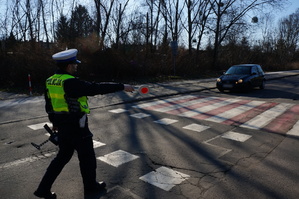 Na zdjęciu policjant z drogówki w trakcie wskazywania kierującemu miejsca zatrzymania pojazdu