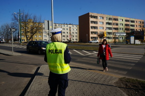 Na zdjęciu mundurowa przy jednym ze świętochłowickich przejść dla pieszych. Policjantka obserwuje zachowanie kierującego w stosunku do pieszej przechodzacej przez oznakowane przejście dla pieszych