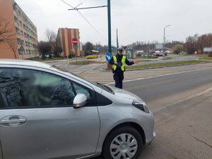 Na zdjęciu mundurowy w trakcie wskazywania miejsca postoju zatrzymanemu do kontroli drogowej kierującemu