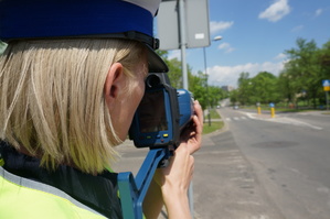 Policjantka w trakcie mierzenia prędkości za pomocą ręcznego miernika, na jednej ze świętochłowickich ulic,