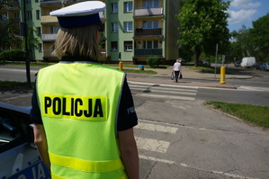 Na zdjęciu mundurowa w trakcie obserwacji zachowania kierujących wobec pieszych na oznakowanym przejściu dla pieszych