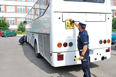 Na zdjęciu policjant z drogówki w trakcie kontroli autokaru