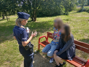 Na zdjęciu policjantka w trakcie rozmowy z osobami przebywającymi w rejonie akwenu