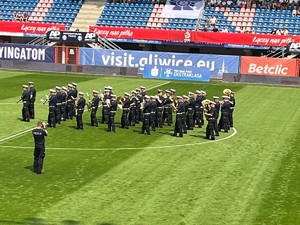 na zdjęciu orkiestra policyjna na murawie stadionu